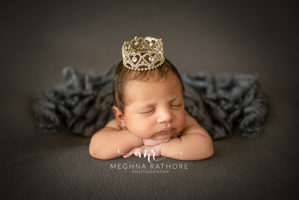 24 days old newborn baby boy posing with props around in professional photoshoot set up at Meghna Rathore photography in gurgaun, new delhi and noida
