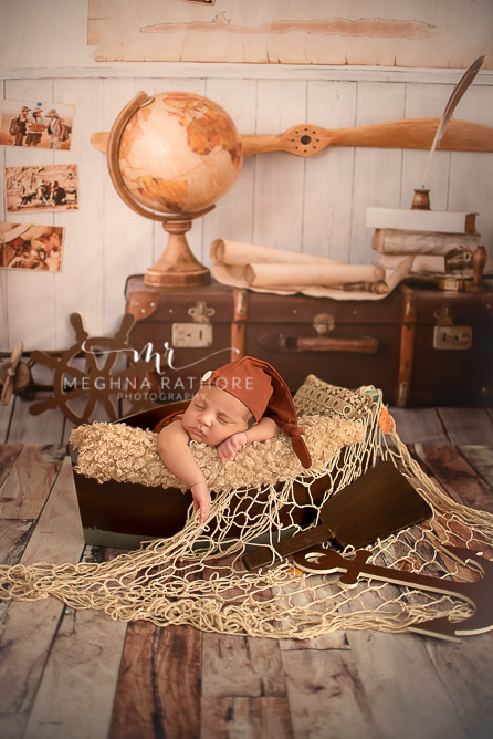 24 days old newborn baby boy posing adorably in cute outfit with cruise theme in professional photoshoot set up at Meghna Rathore photography in gurgaun, new delhi and noida