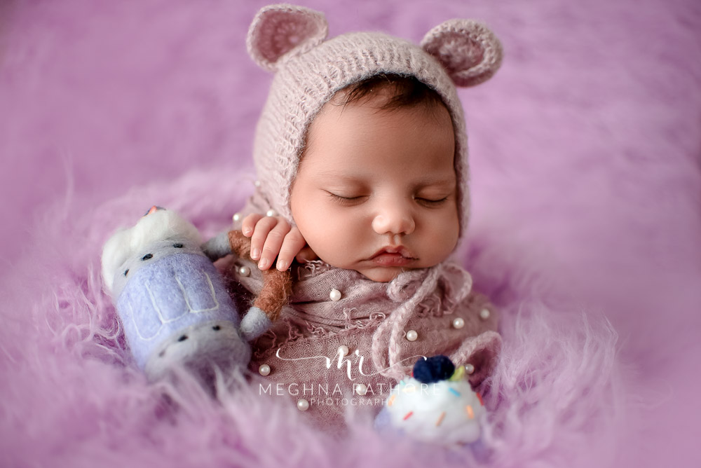 24 days old newborn girl child wearing a bunny shaped woolen cap best indoor photo studio at meghna rathore photography in gurgaoun