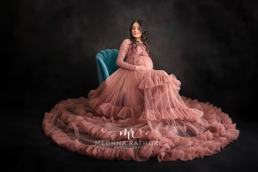 Professional shoot of Mother in peach gown during maternity shoot with black background in Delhi